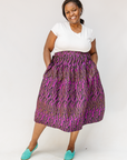Model wearing fuchsia skirt with small dot design.