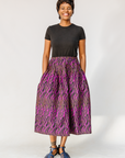 Model wearing fuchsia skirt with small dot design.