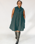 Model wearing sleeveless black dress with teal moon design.