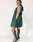 Model wearing sleeveless black dress with teal moon design.