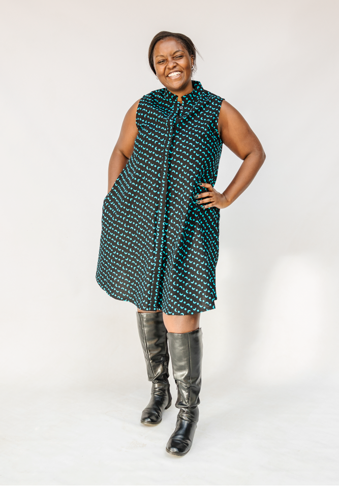 Model wearing sleeveless black dress with teal moon design.