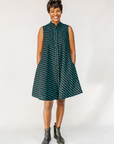 Model wearing sleeveless black dress with teal moon design.