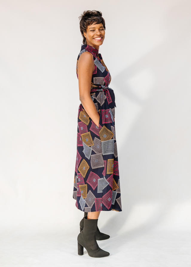 Model wearing pink, orange, white and black geometric print dress.