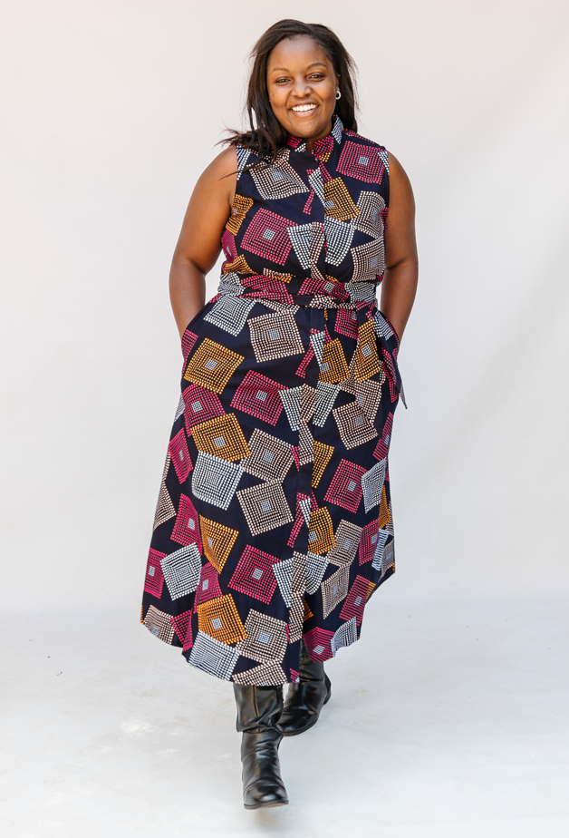 Model wearing pink, orange, white and black geometric print dress.