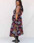 Model wearing pink, orange, white and black geometric print dress.