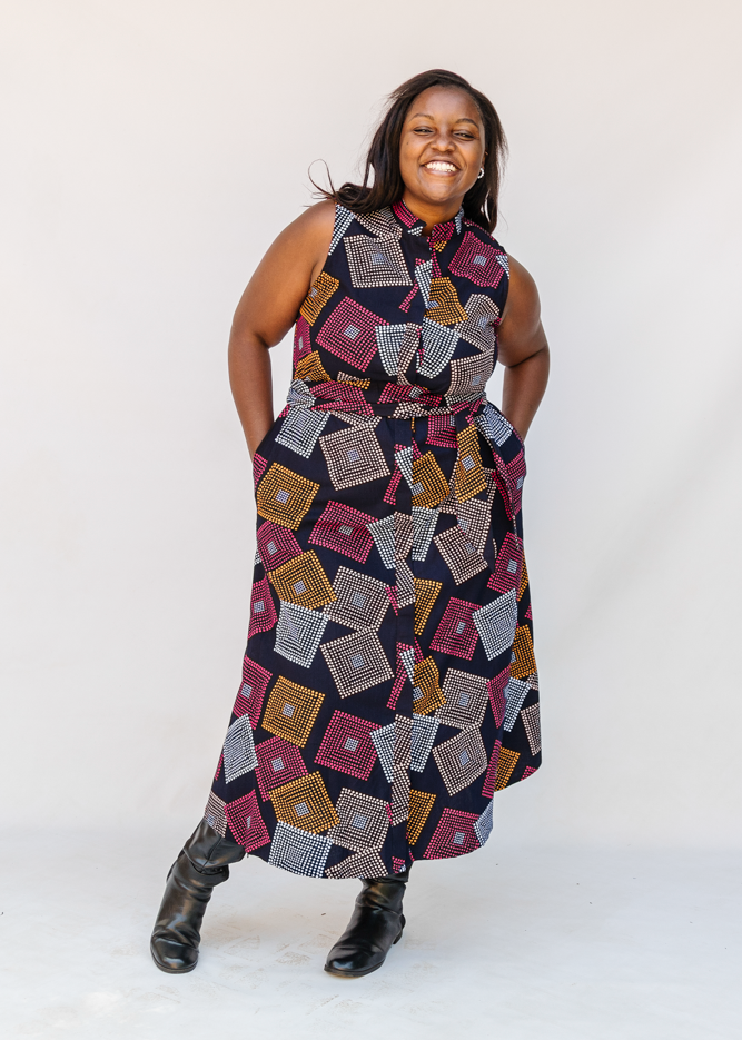 Model wearing pink, orange, white and black geometric print dress.