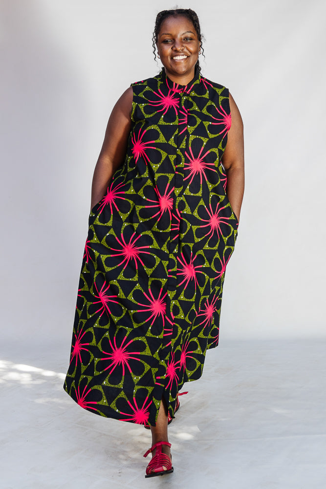 Model wearing navy and green dress with pink floral print.