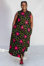 Model wearing navy and green dress with pink floral print.