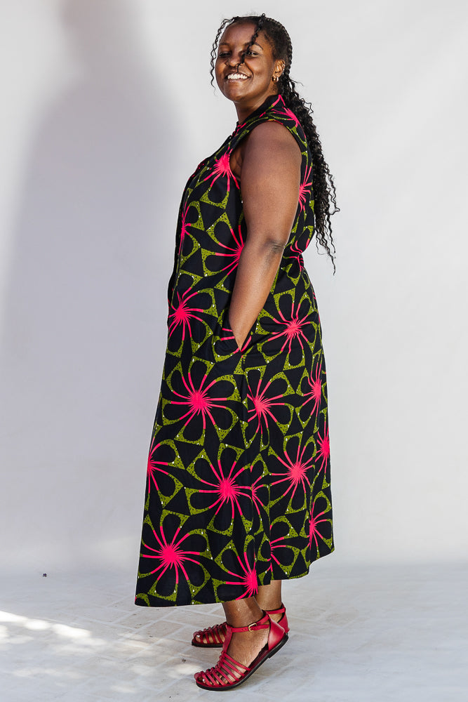 Model wearing navy and green dress with pink floral print.