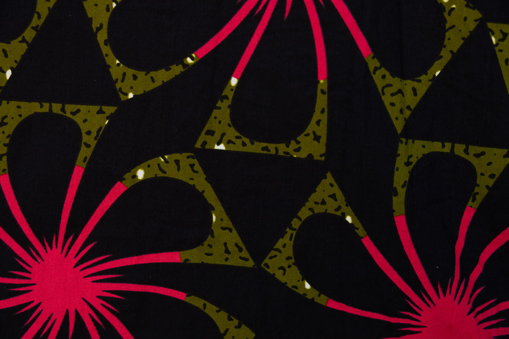 Close up display of navy and green dress with pink floral print, fabric.