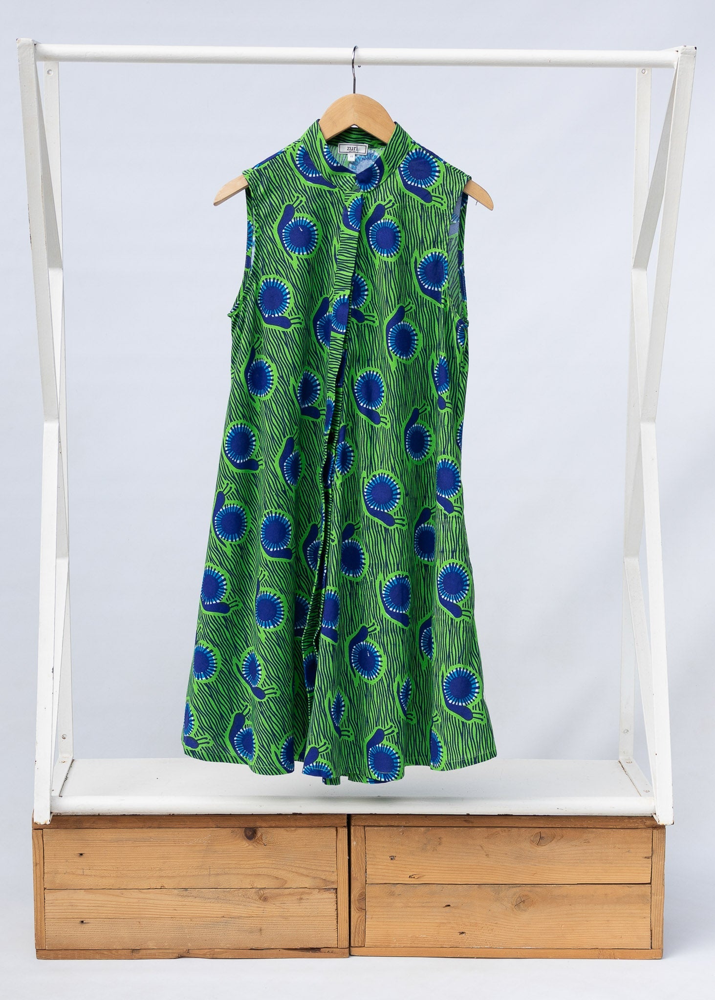 Display of sleeveless dress with green and blue snail print.