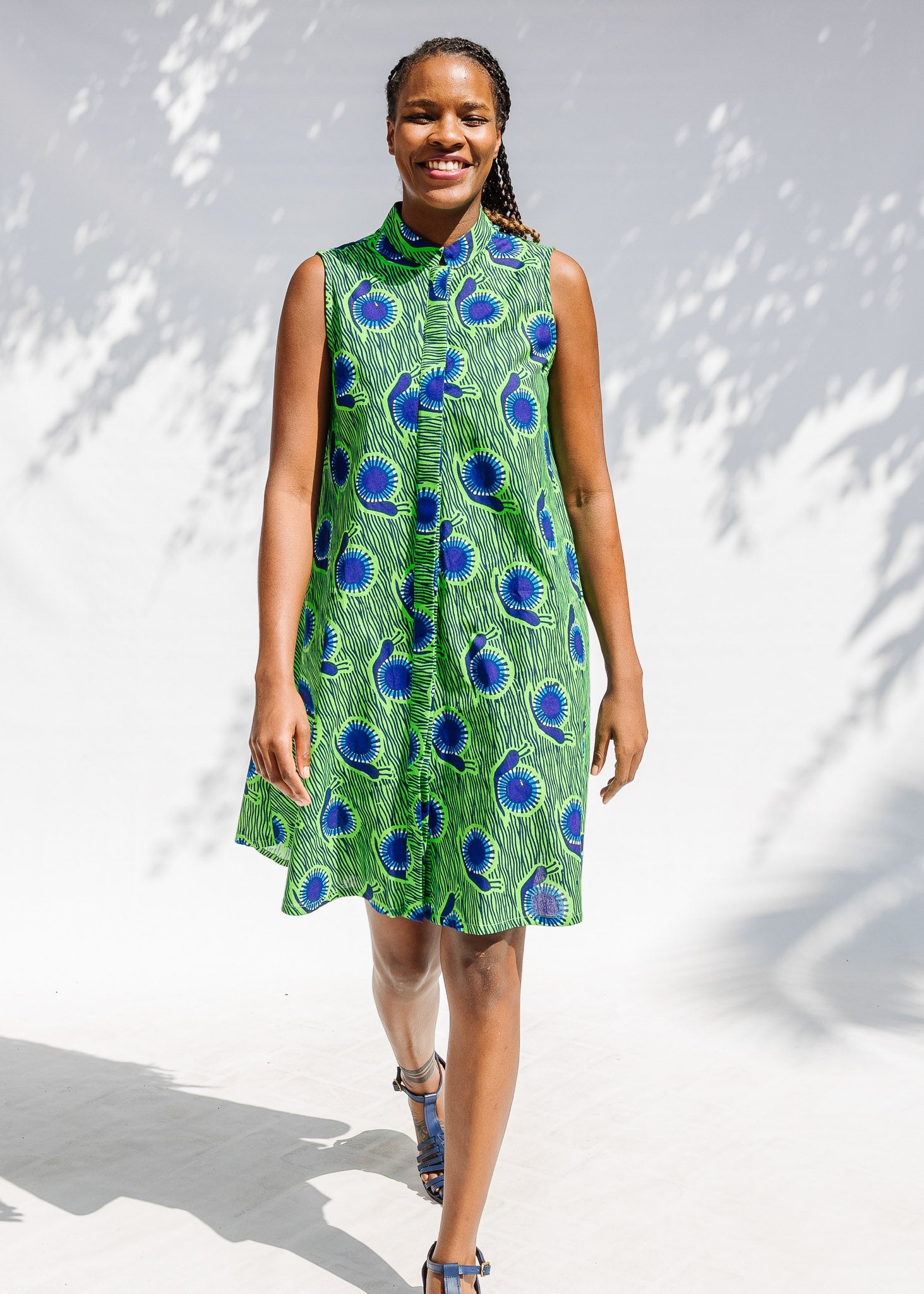 Model wearing sleeveless dress with green and blue snail print.