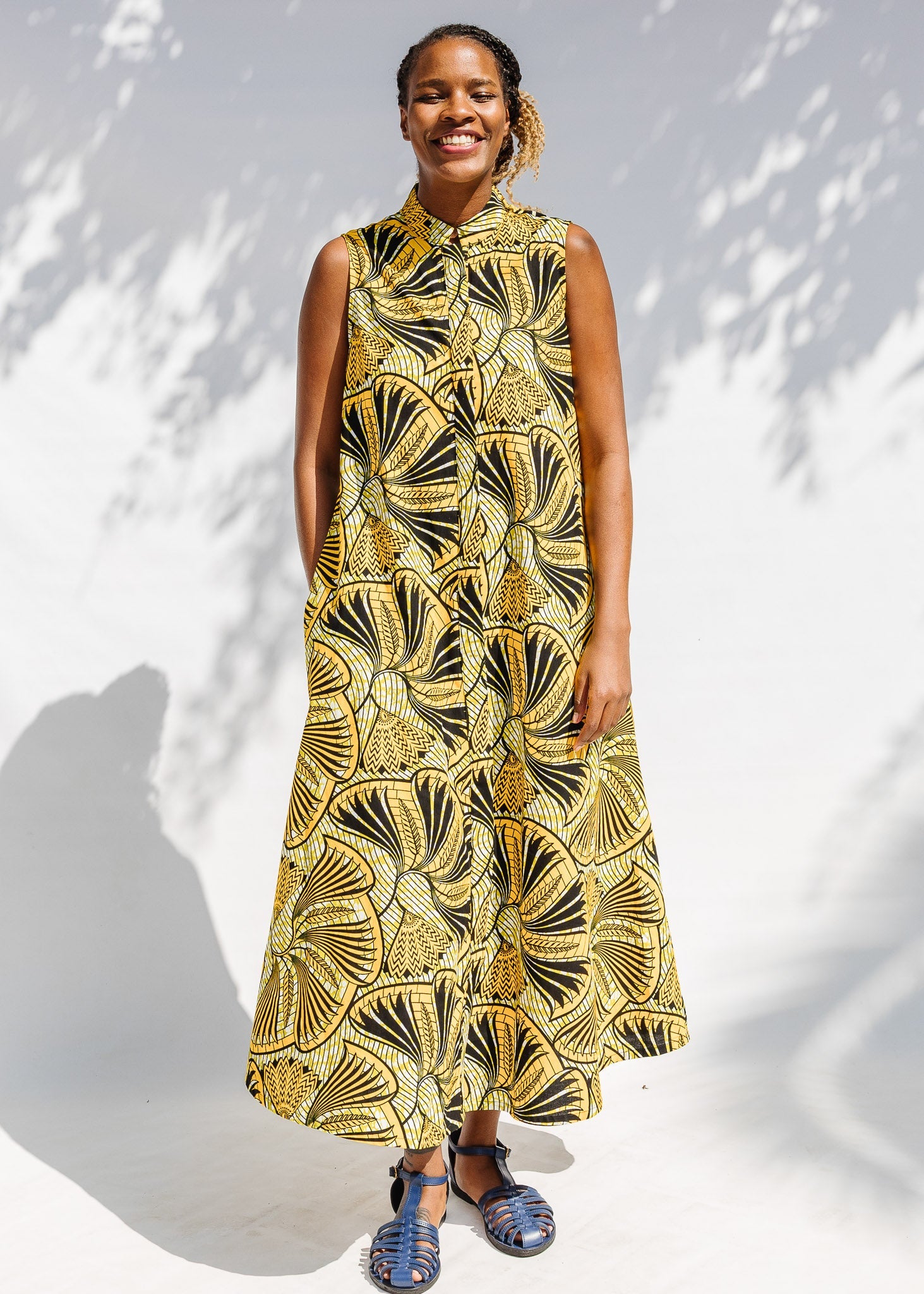 Model wearing yellow and black sleeveless maxi dress.
