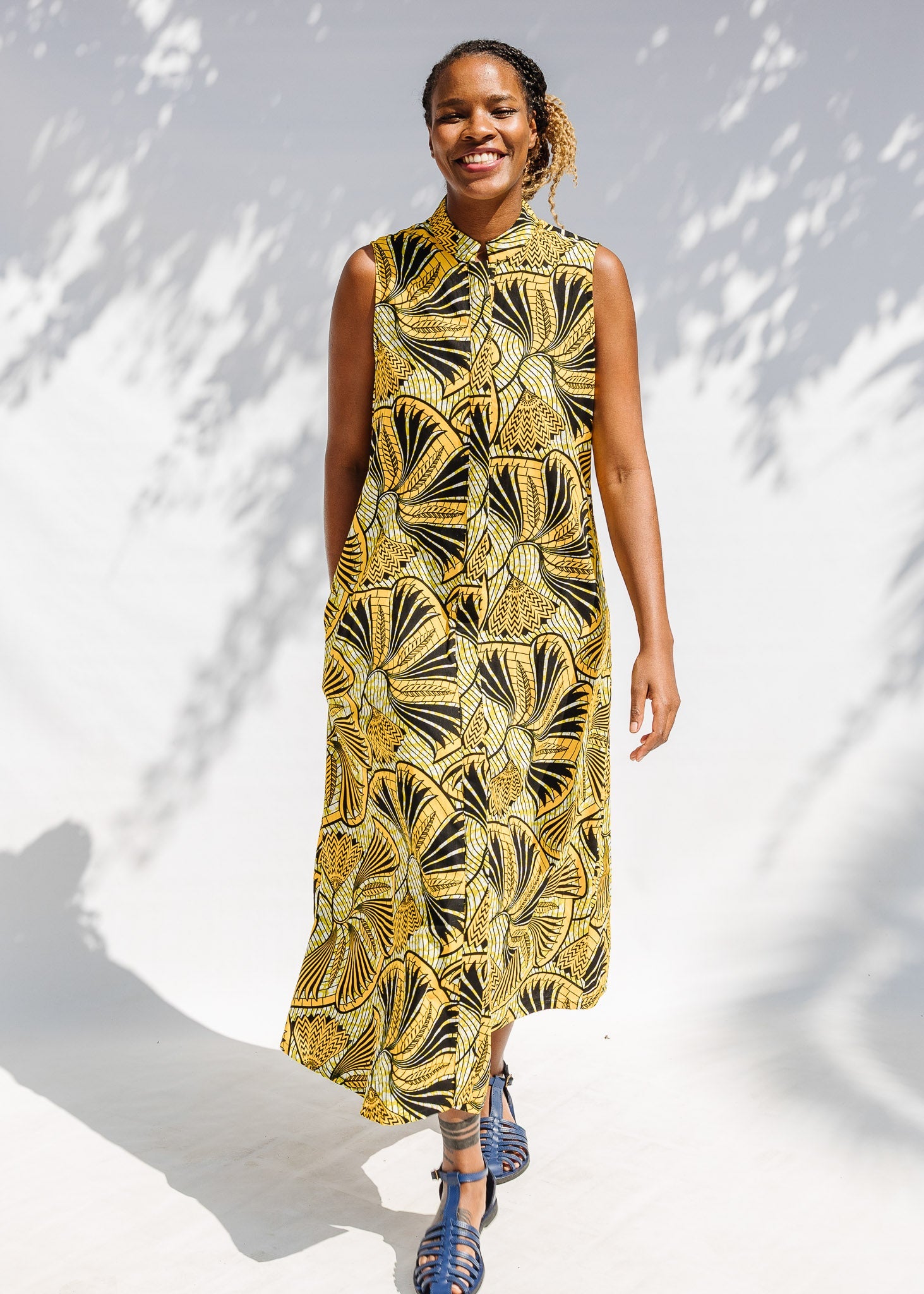 Model wearing yellow and black sleeveless maxi dress.