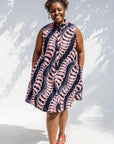 Model wearing black and pink sleeveless print dress.