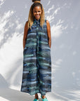 Model wearing black dress with aqua and navy abstract print.
