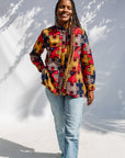 Model wearing multicolored puzzle print shirt.