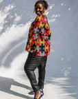 Model wearing multicolored puzzle print shirt.