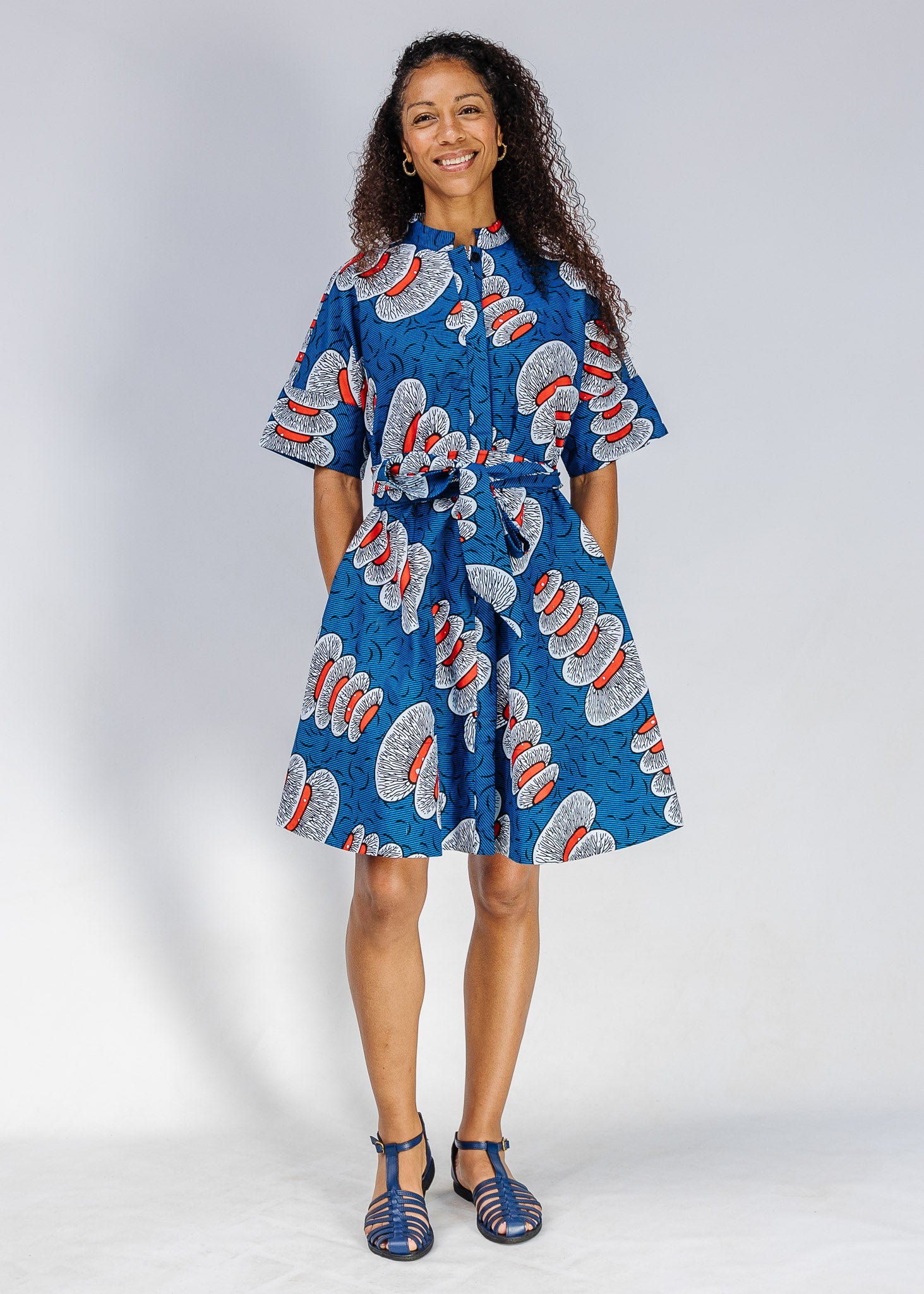 Woman wearing a blue patterned dress on a white background
