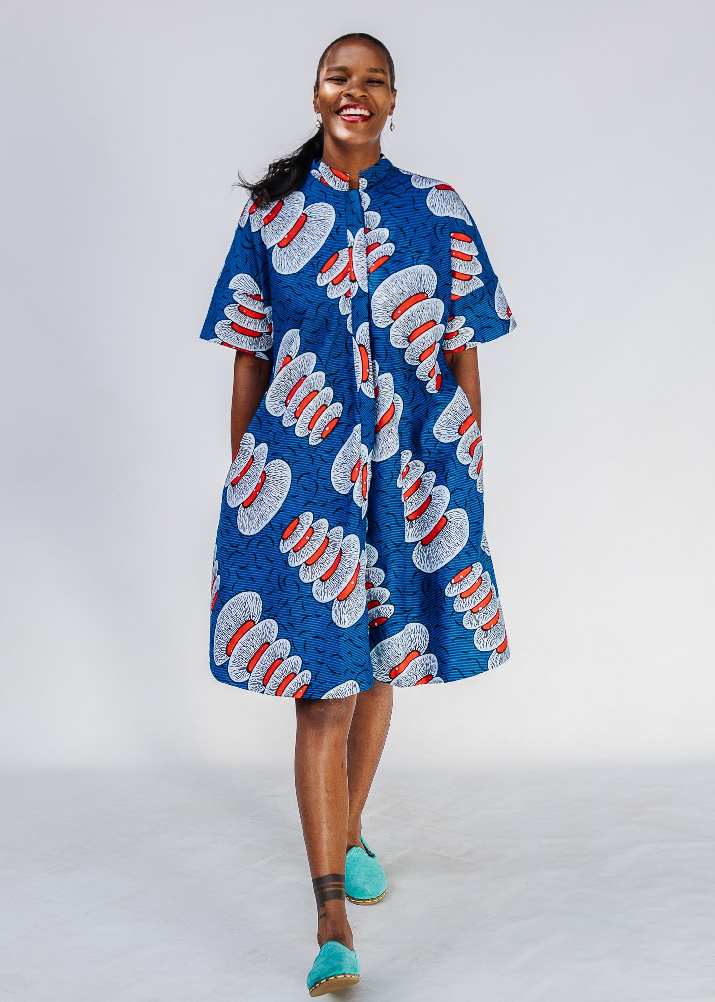 Woman wearing a blue patterned dress on a white background