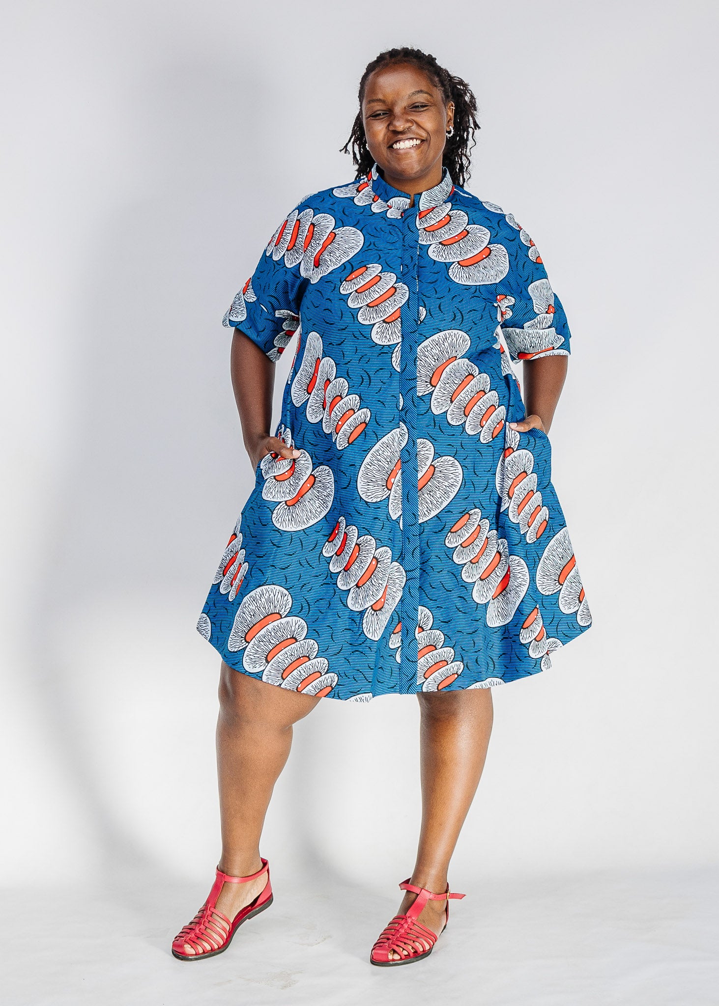Woman wearing a blue patterned dress on a white background