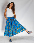 Model wearing white shirt with blue pants with beige fish print.