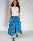 Model wearing white shirt with blue pants with beige fish print.