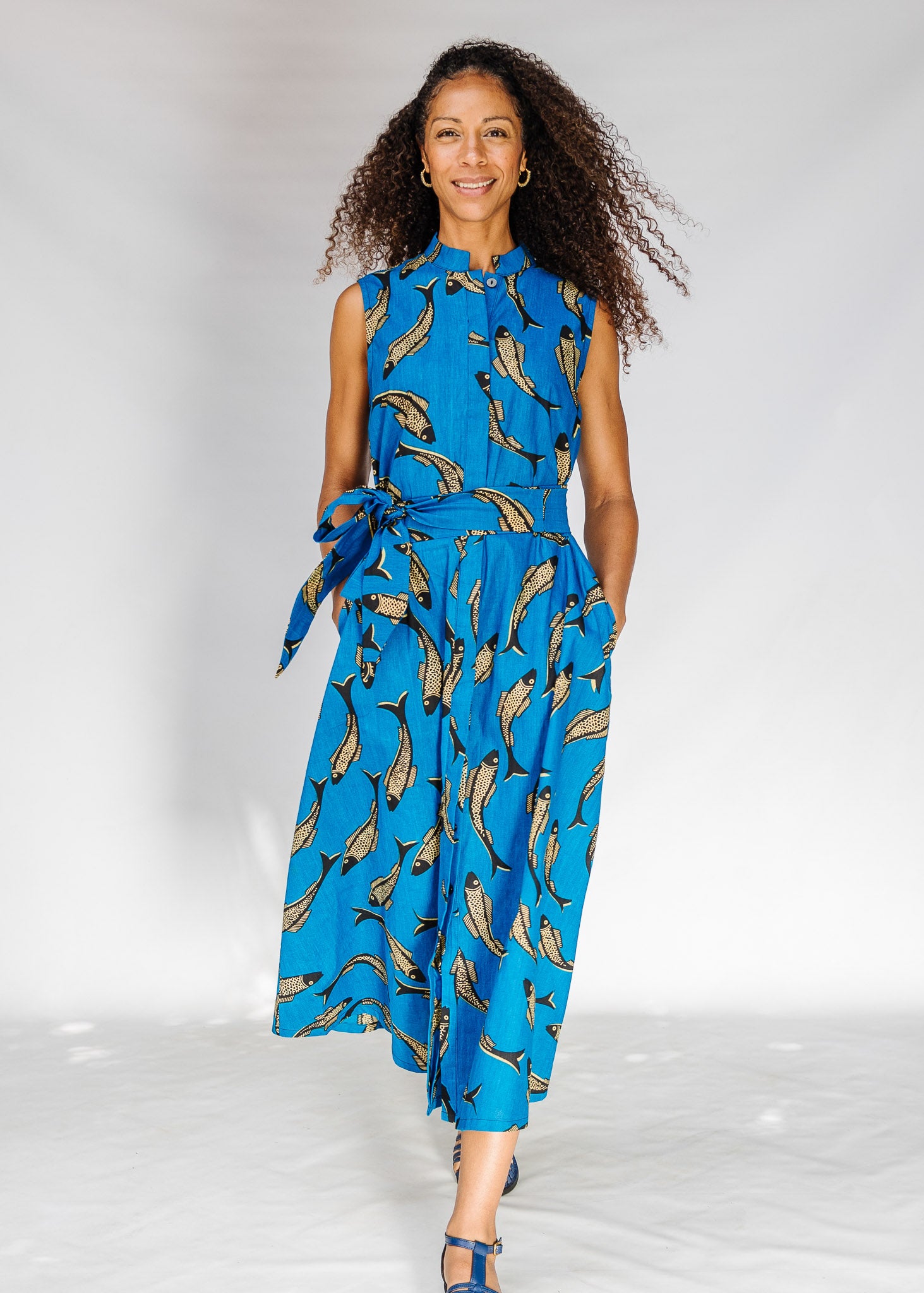 Woman wearing a blue dress with FISH print on a white background