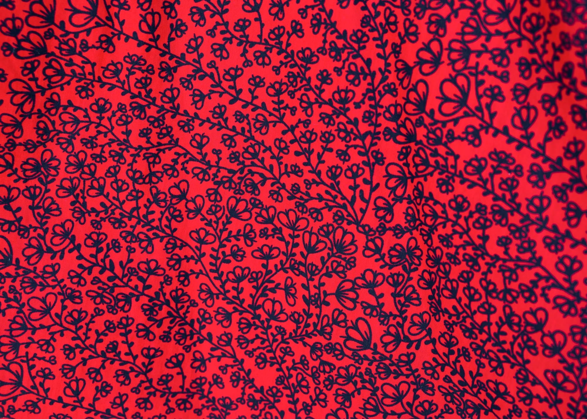 detail of a red and black leaf design dress
