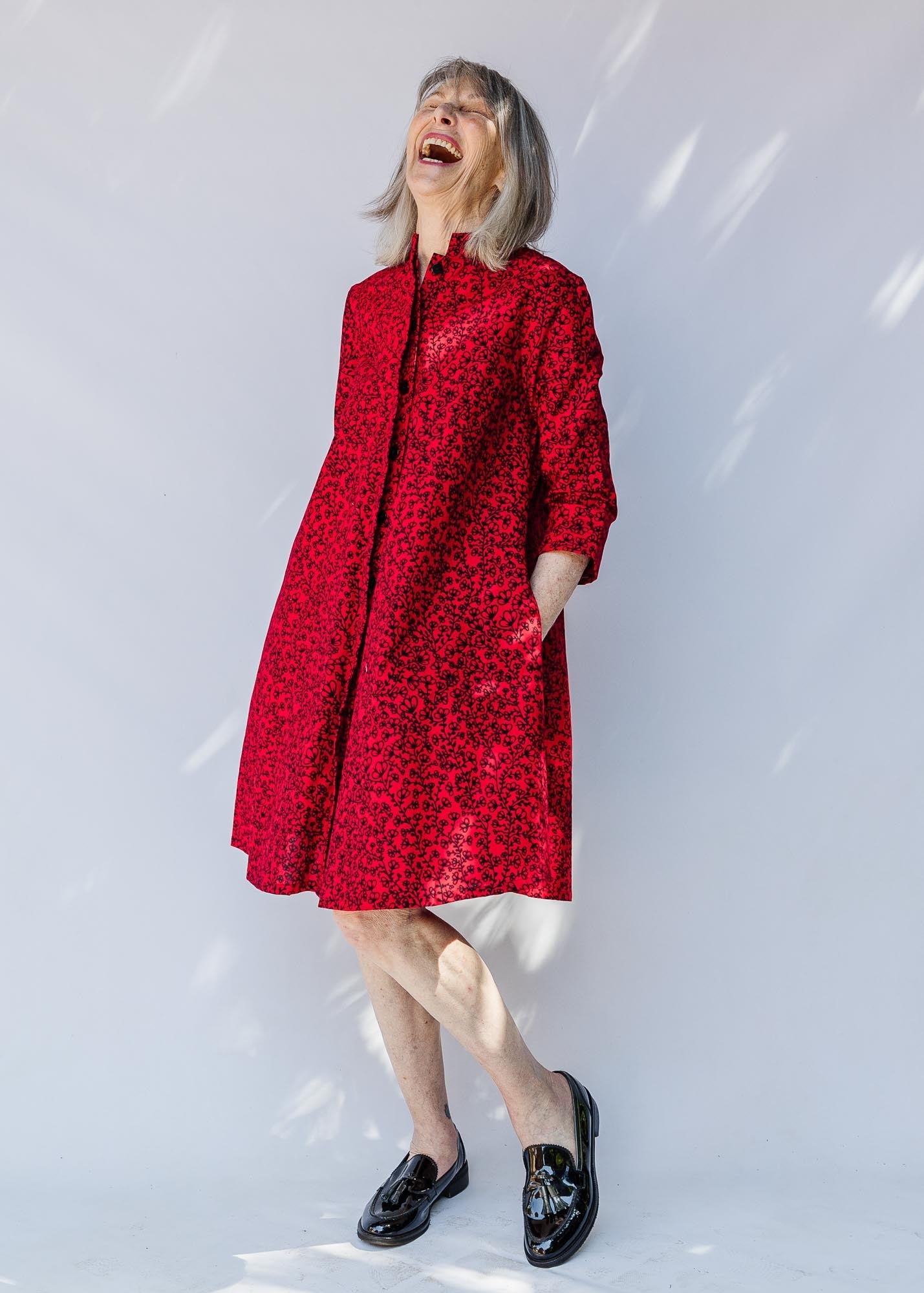 model wearing a red and black leaf design dress