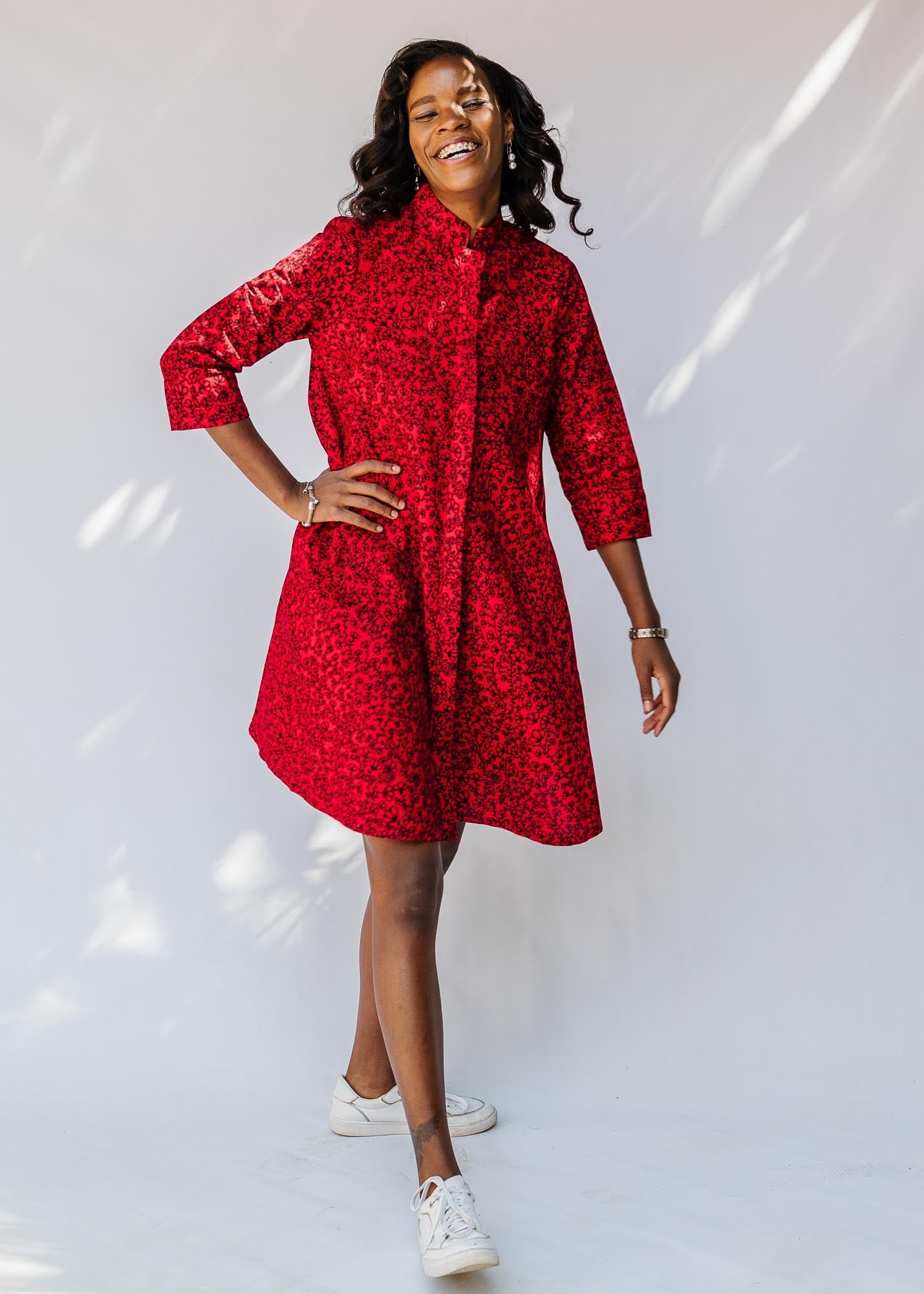 model wearing a red and black leaf design dress