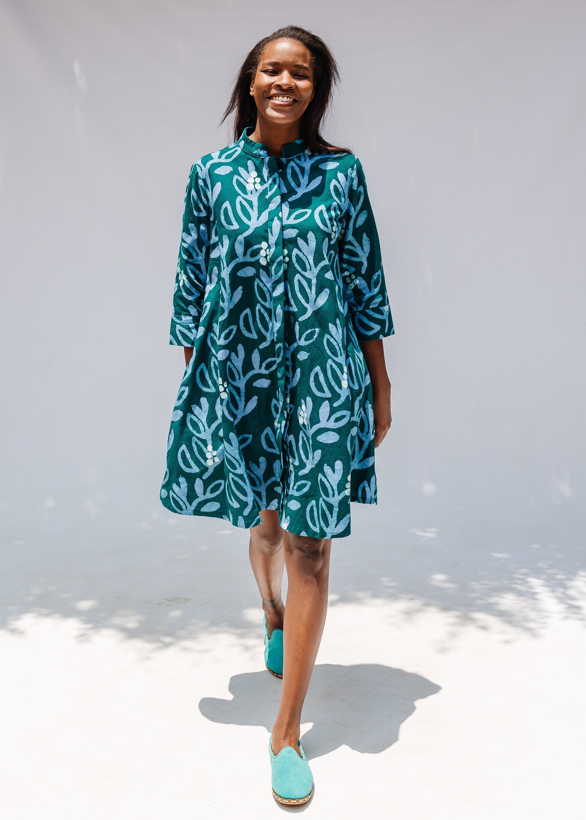Model wearing green and blue floral batik dress.