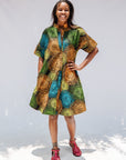 Model wearing black dress with orange, yellow, blue and green swirls.