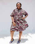 Model wearing pink, black and white glitter print dress