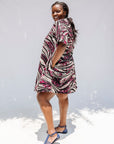 Model wearing pink, black and white glitter print dress